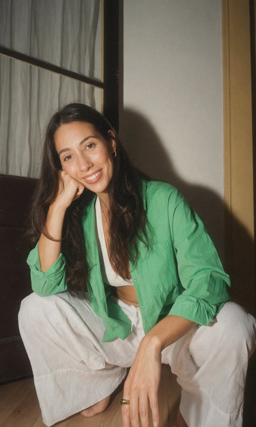 Serena, founder of Anima Serena, smiling with her hand resting on her cheek